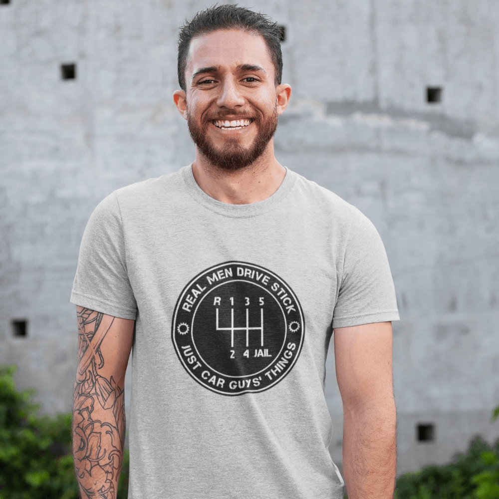 petrolhead who's wearing a "Real men drive stick" car t-shirt made for car guys, JDM drifting t-shirt, save the manuals t-shirt, 3 pedals - clutch brake gas, a cool t-shirt made for drifters and car lovers, made in the USA, excellent quality print, free shipping, sale 40% off,  car enthusiasts love it, athletic heather color